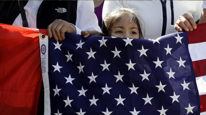 USA and Mexican flag in the hand of a child