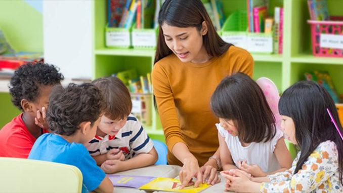 The teacher teaching the children in kindergarten