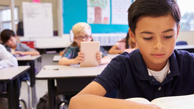 A Latino Boy In School Studying