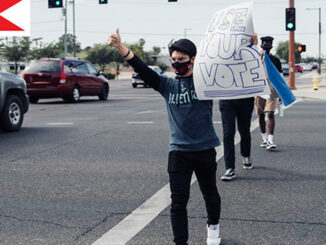 A Young Boy Holding Banner Of Use Your Vote