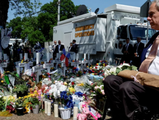 A man selling flowers near the emergency operation vehicle